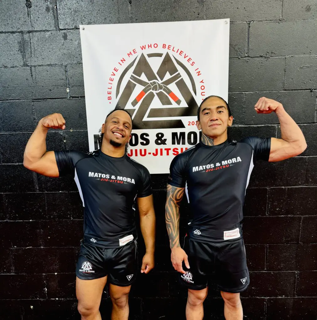 Coaches Kelvyn Matos and Manny Mora in front of the Matos & Mora banner