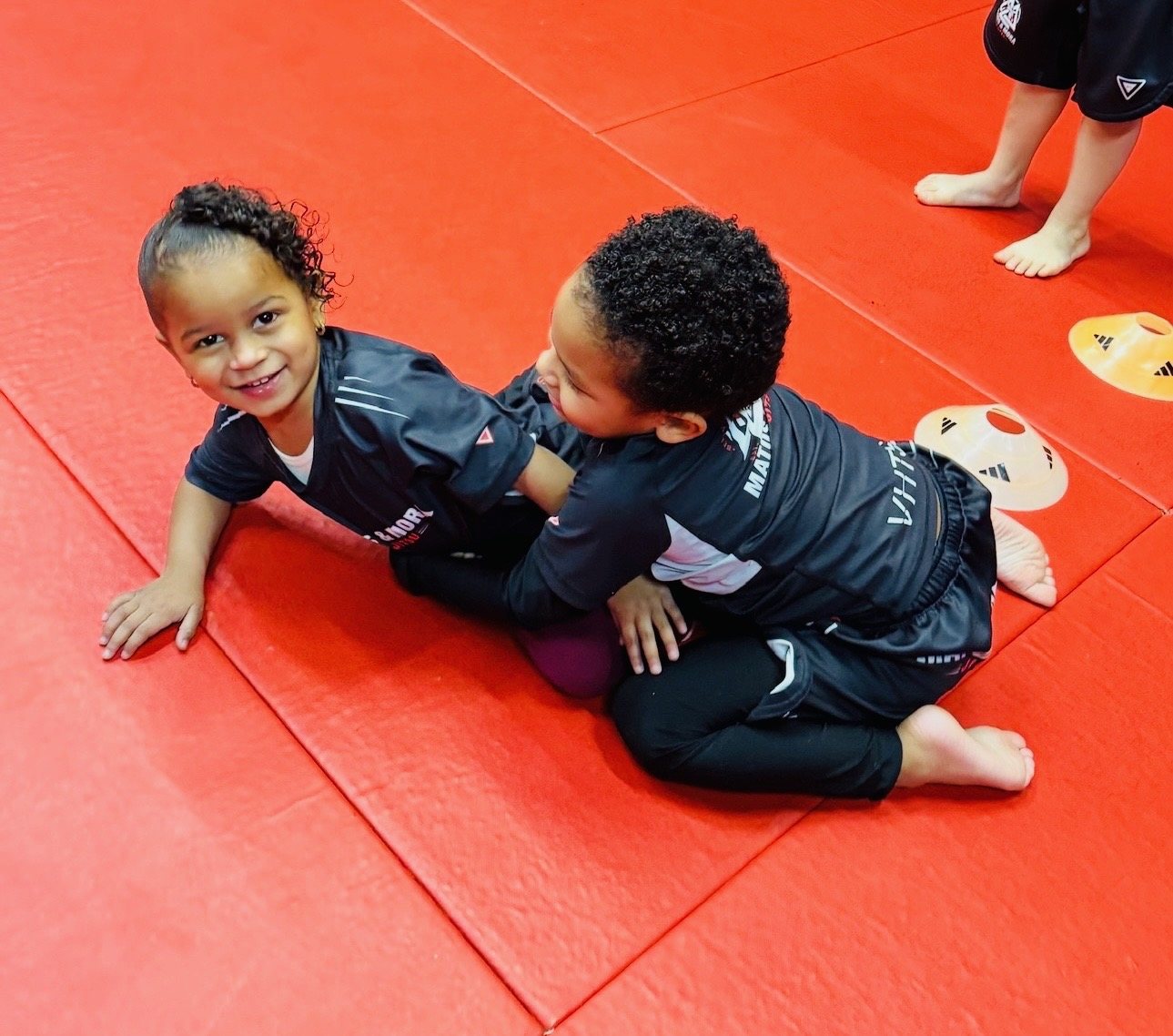 Two young students training together in Kids Jiu-Jitsu